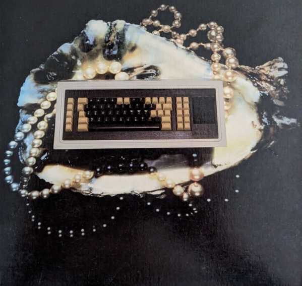keyboard laying on top of an oyster shell and a pearl necklace